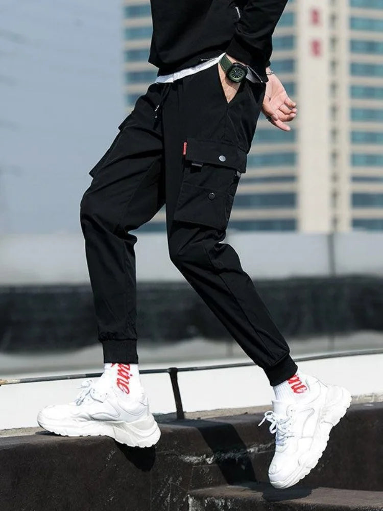 بنطال رياضي رجالي كاجوال متعدد الجيوب بلون موحد، بخصر مطاطي متوسط الارتفاع وأساور قابلة للانكماش برباط